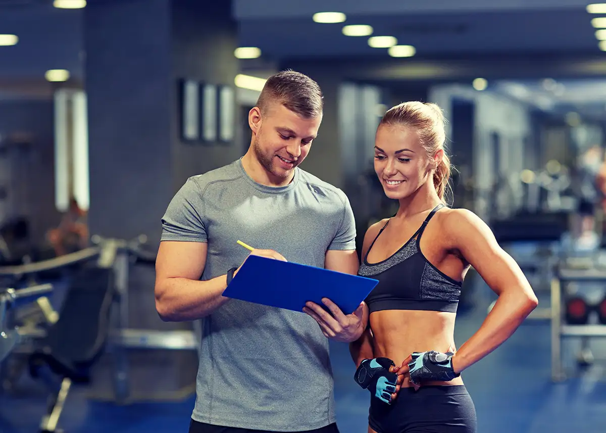 Personal trainer working with client at the gym, mapping out progress - Collinsville, IL - Bethalto, IL